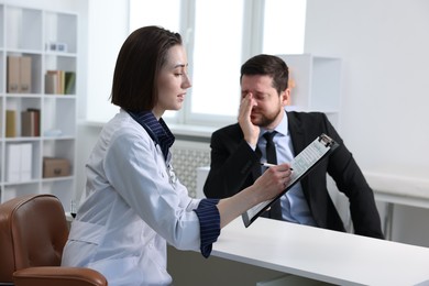 Photo of Alcoholic man having appointment with healthcare specialist in clinic. Addiction treatment