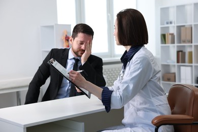 Photo of Alcoholic man having appointment with healthcare specialist in clinic. Addiction treatment