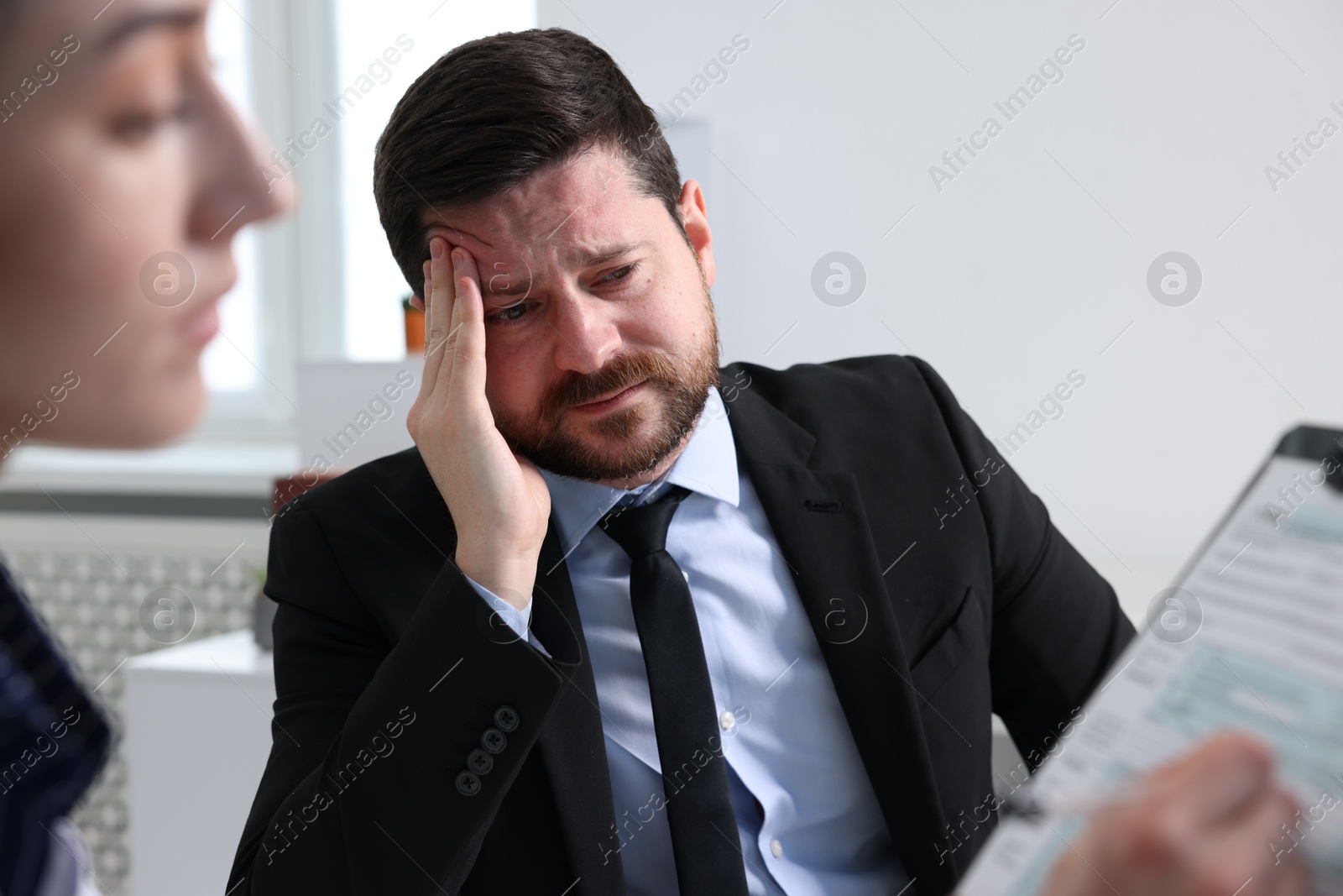 Photo of Alcoholic man having appointment with healthcare specialist in clinic. Addiction treatment