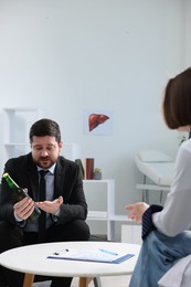 Photo of Alcoholic man having appointment with healthcare specialist in clinic. Addiction treatment