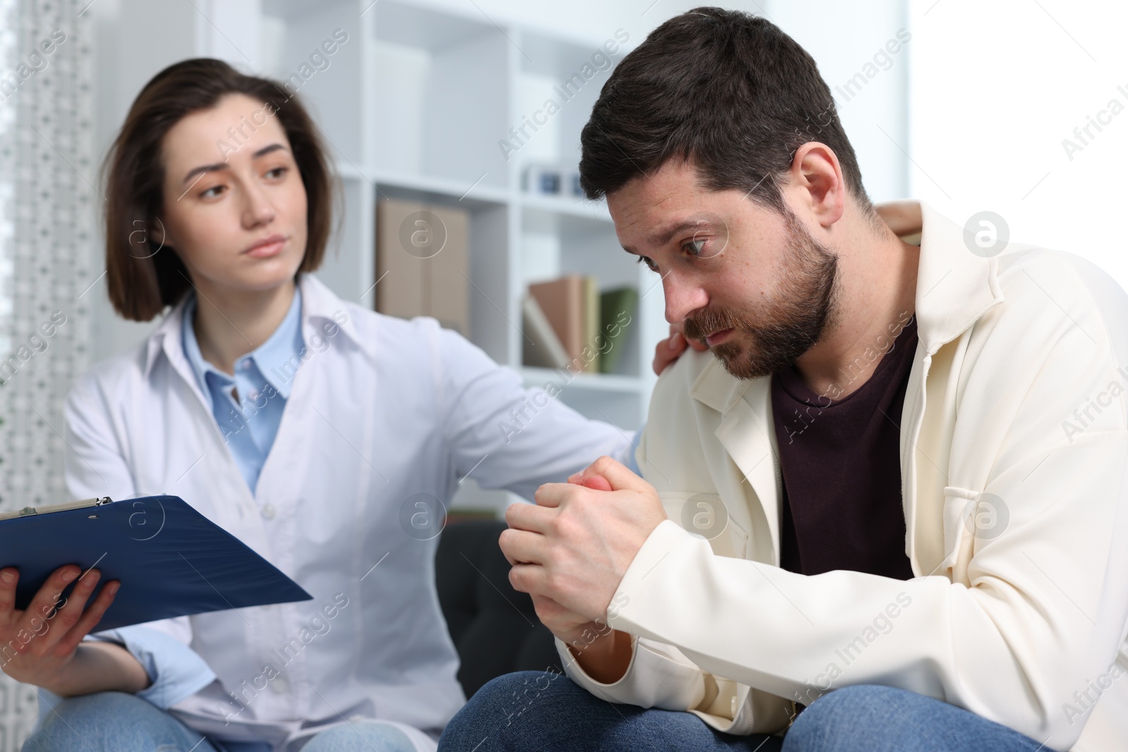 Photo of Alcoholic man having appointment with healthcare specialist in clinic. Addiction treatment