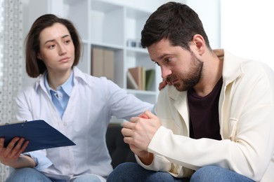 Photo of Alcoholic man having appointment with healthcare specialist in clinic. Addiction treatment