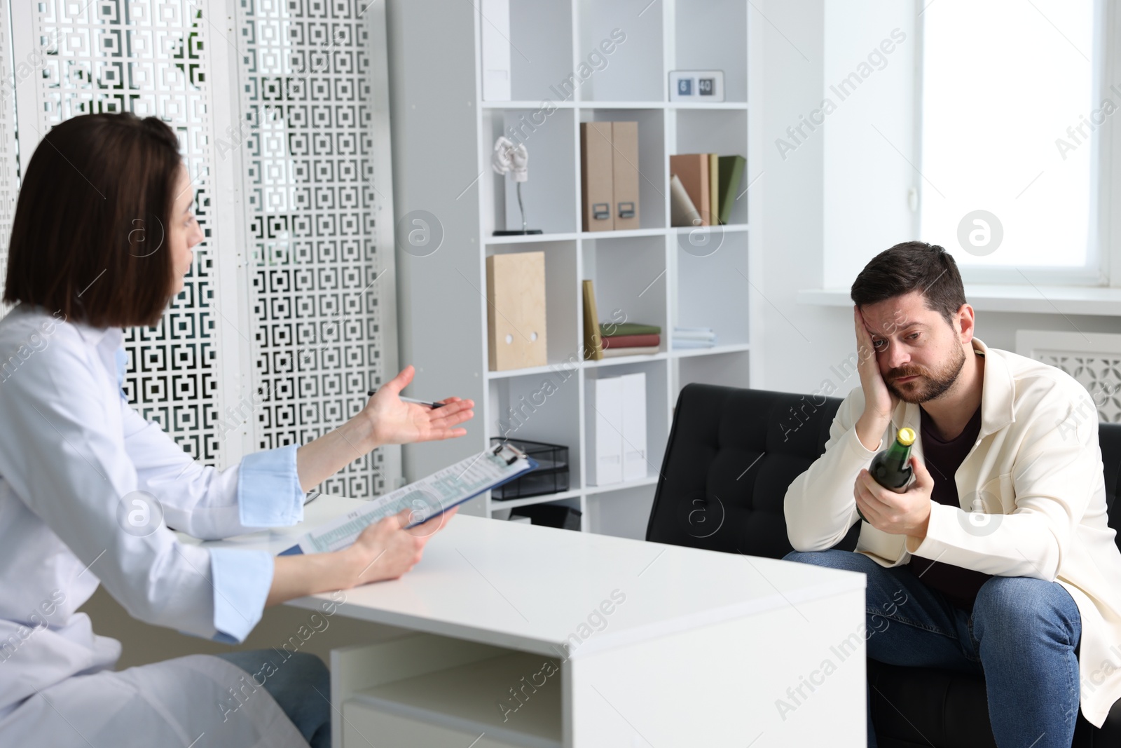 Photo of Alcoholic man having appointment with healthcare specialist in clinic. Addiction treatment