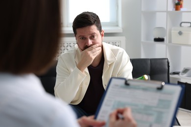 Photo of Alcoholic man having appointment with healthcare specialist in clinic. Addiction treatment