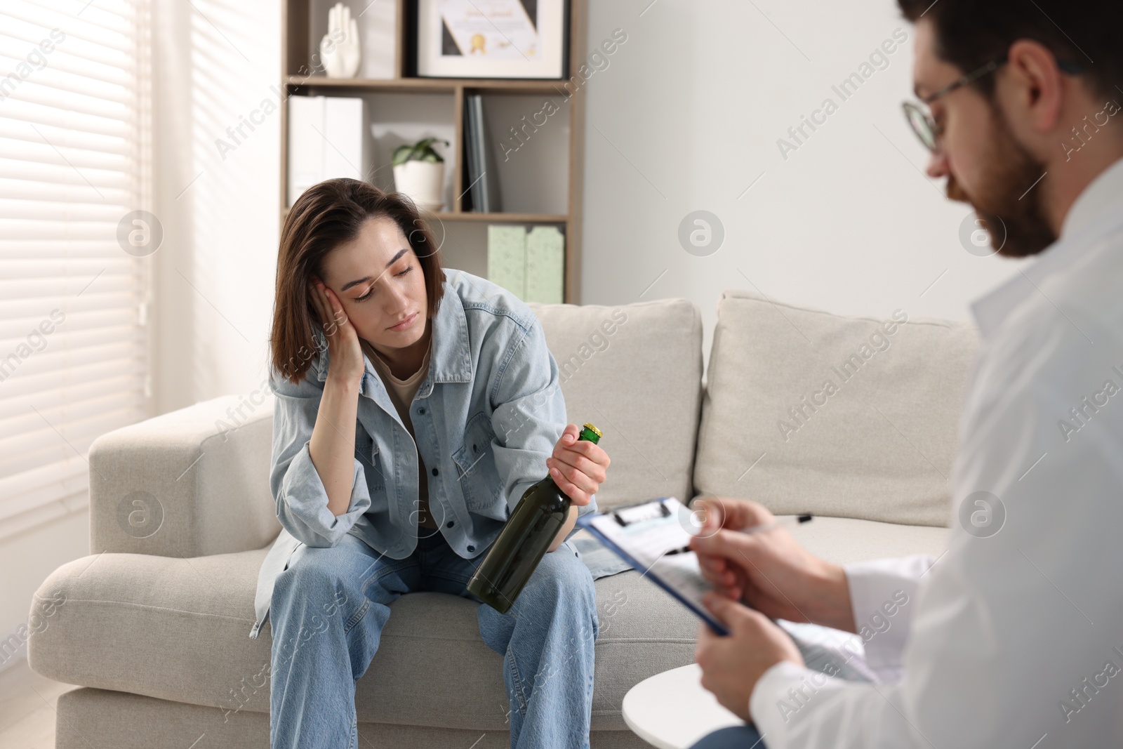 Photo of Alcoholic woman having appointment with healthcare specialist in clinic. Addiction treatment