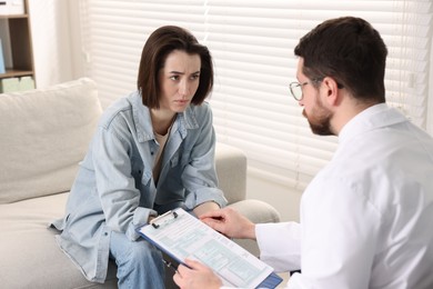 Photo of Alcoholic woman having appointment with healthcare specialist in clinic. Addiction treatment