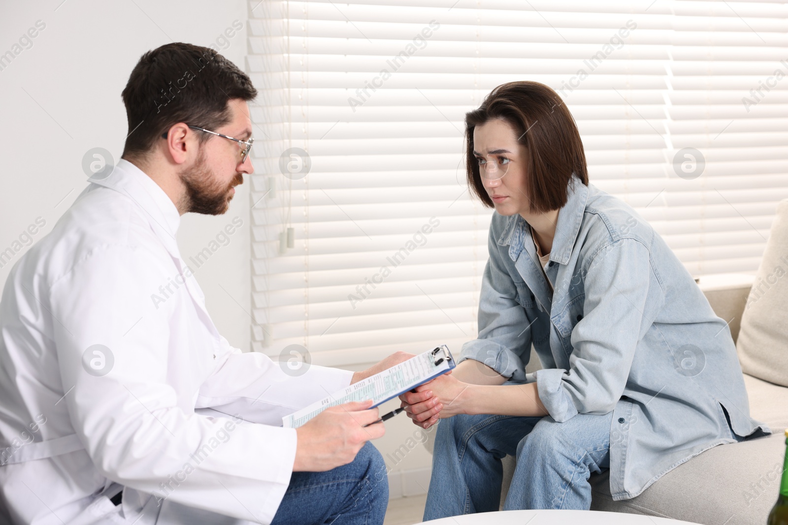 Photo of Alcoholic woman having appointment with healthcare specialist in clinic. Addiction treatment