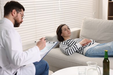 Photo of Alcoholic woman having appointment with healthcare specialist in clinic. Addiction treatment