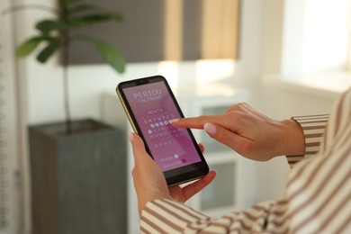 Photo of Menstruation. Woman using period calendar application on smartphone indoors, closeup. Space for text