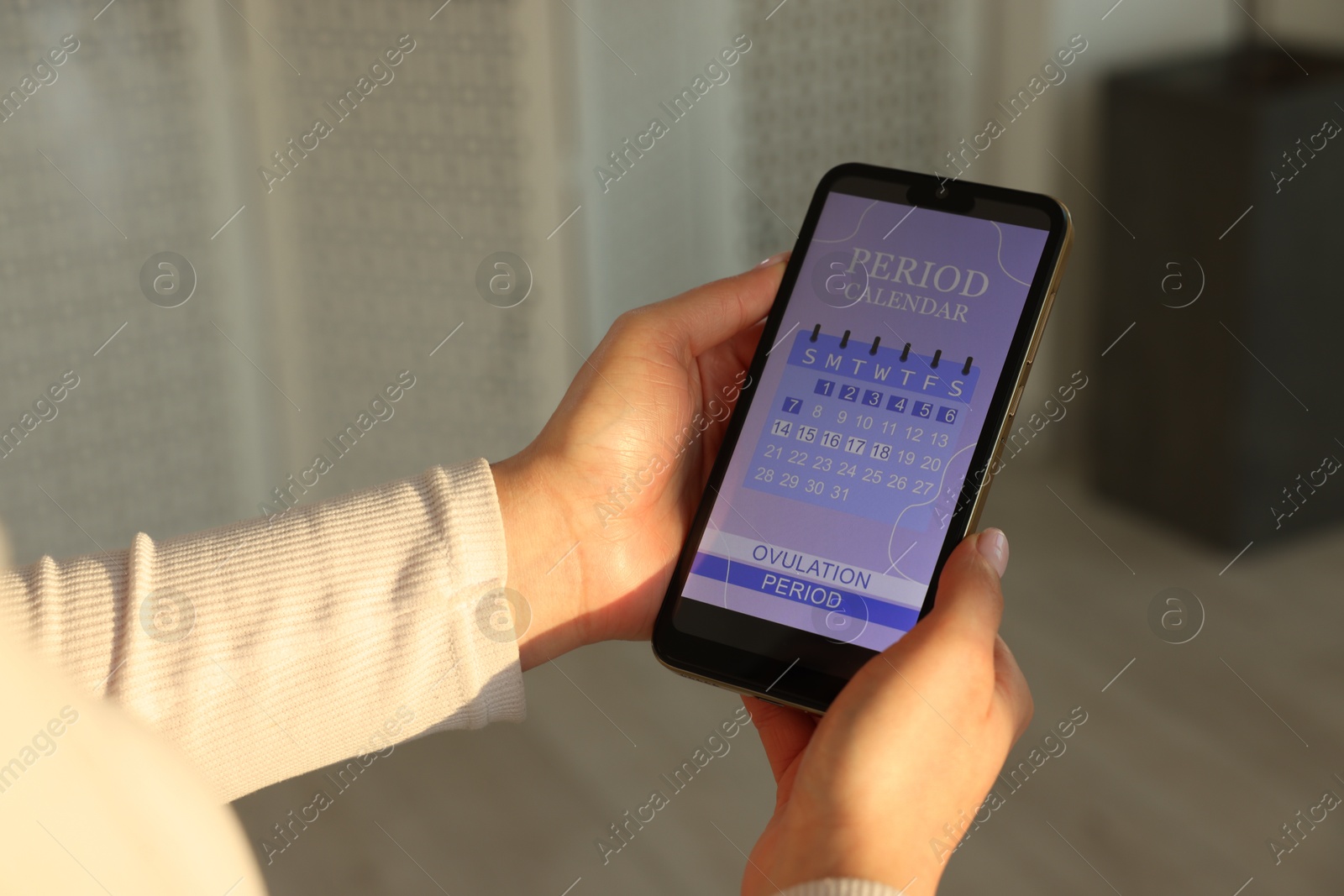 Photo of Menstruation. Woman using period calendar application on smartphone indoors, closeup