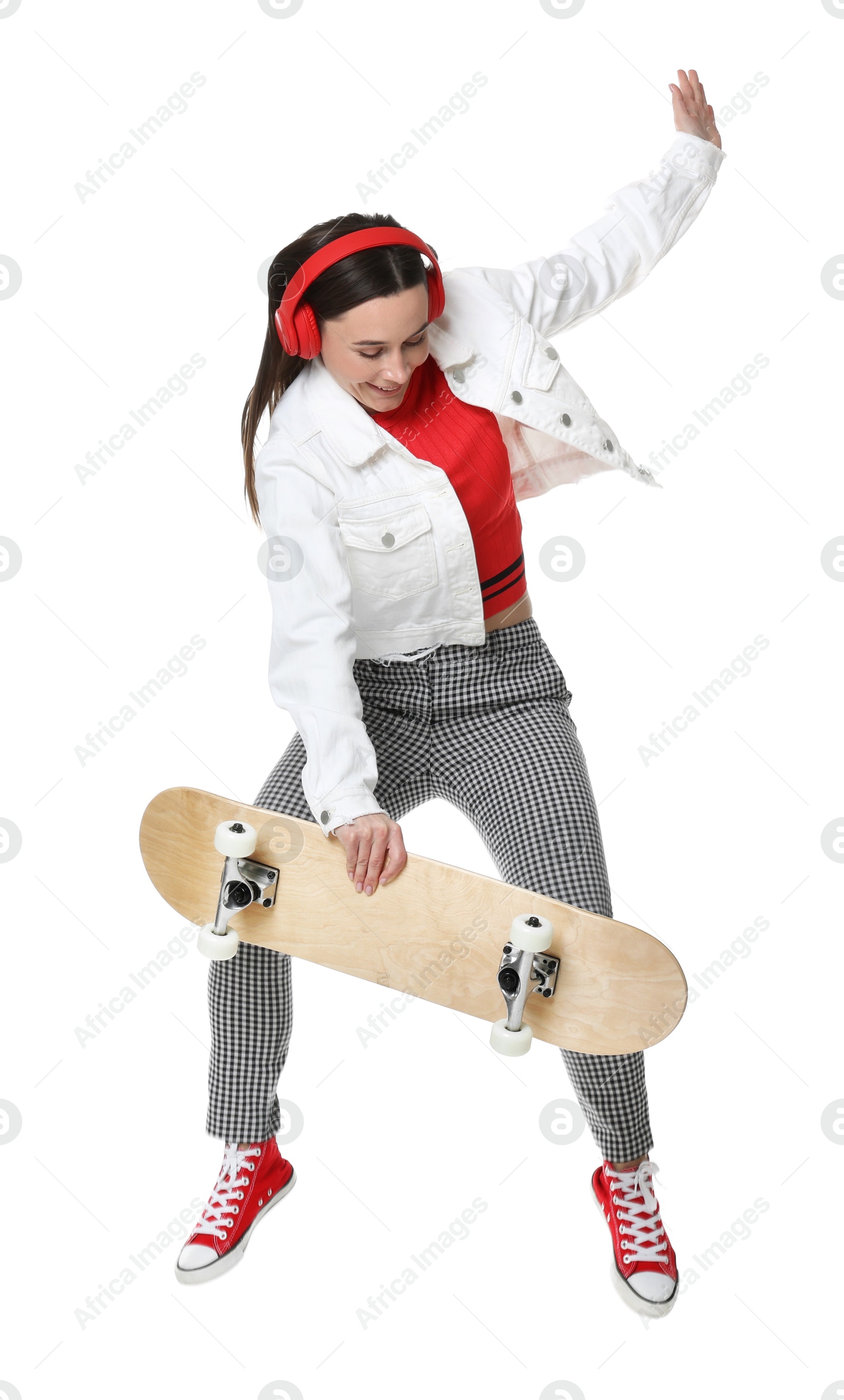 Photo of Smiling woman jumping with skateboard on white background