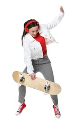 Photo of Smiling woman jumping with skateboard on white background