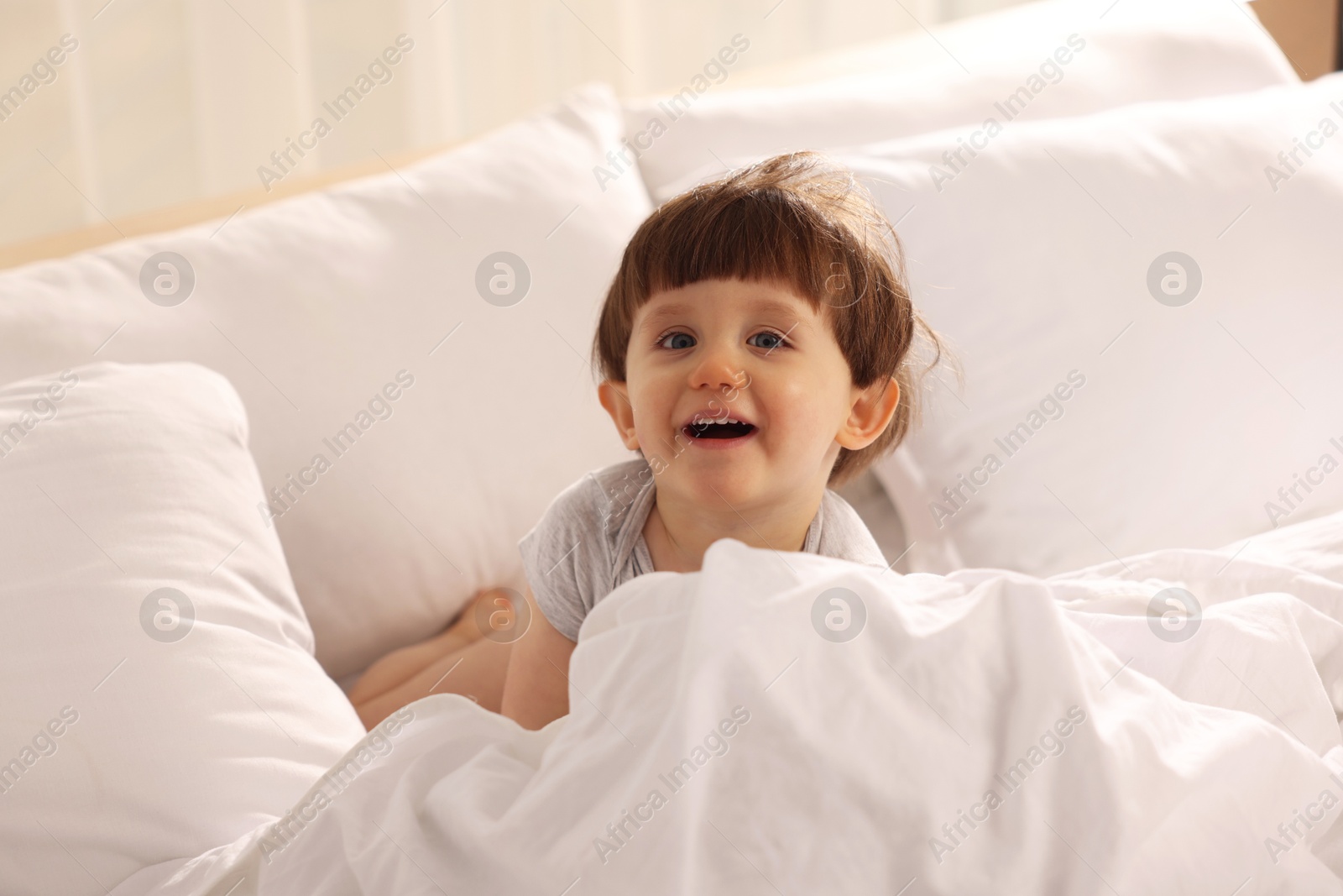 Photo of Cute little boy in bed at home