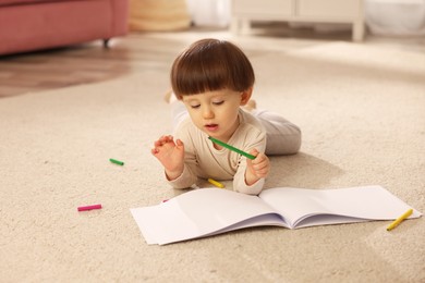 Photo of Cute little boy drawing on floor at home, space for text