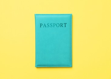 Photo of Passport in bright cover on yellow background, top view