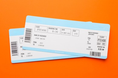 Photo of Travel agency. Flight tickets on orange background, top view