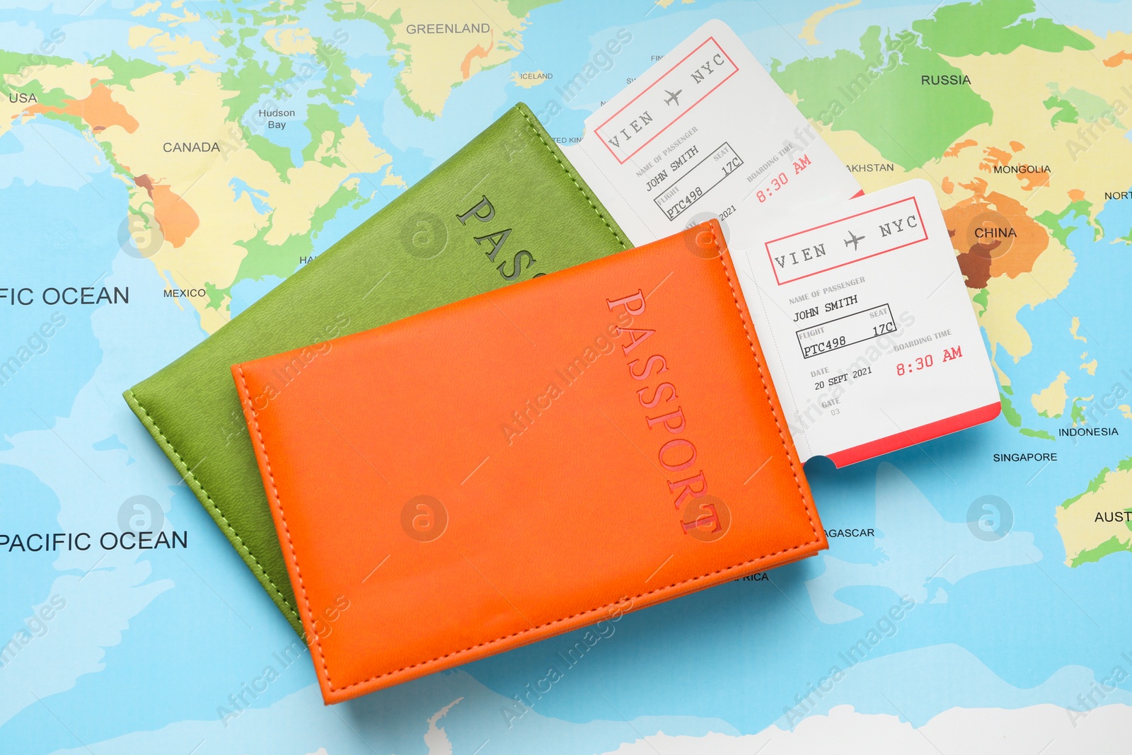 Photo of Travel agency. Flight tickets and passports on world map, flat lay