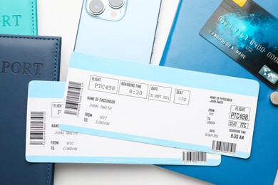 Photo of Travel agency. Flight tickets, passports, smartphone, notebook and credit card on light background, flat lay