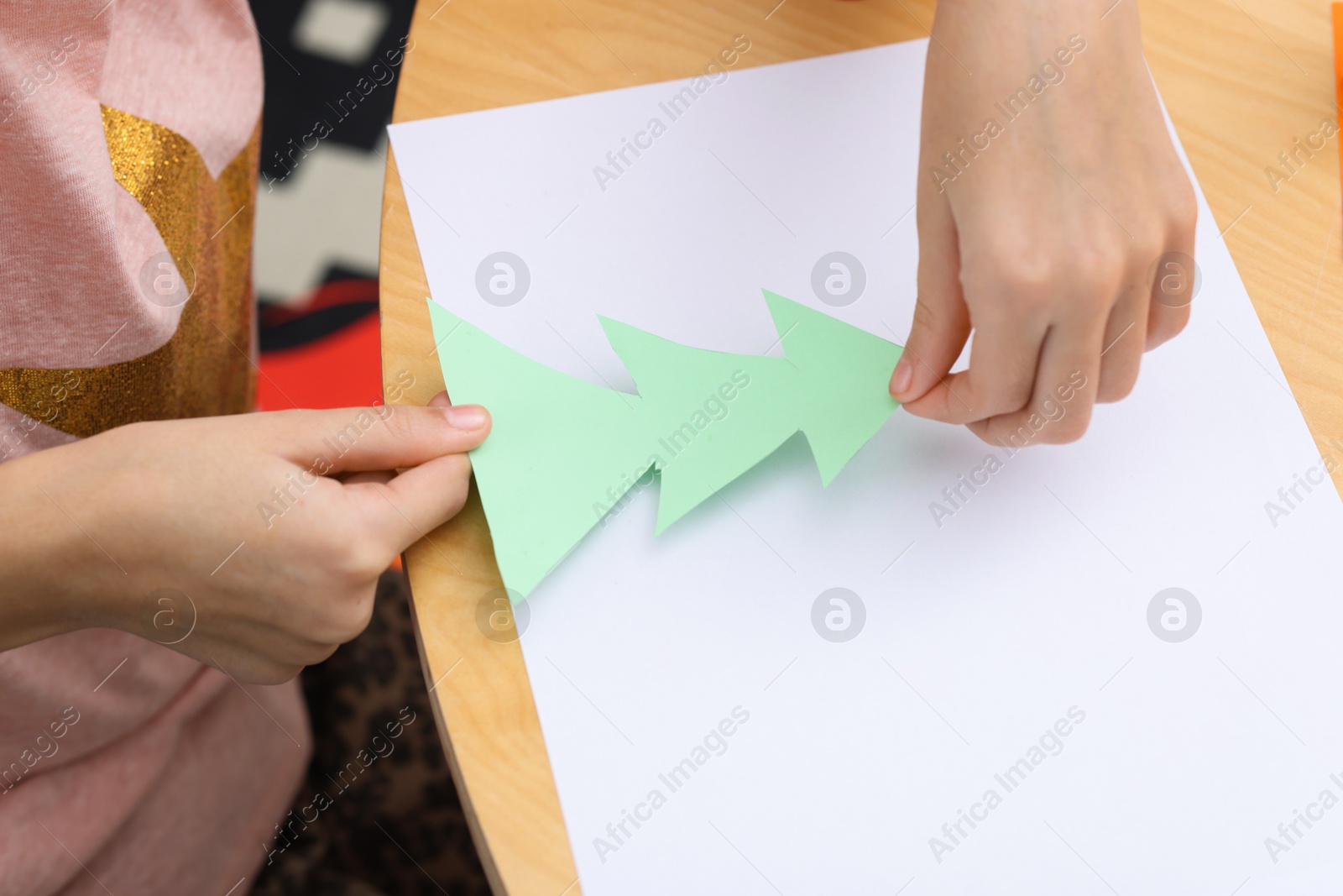 Photo of Girl making art project at table indoors, closeup