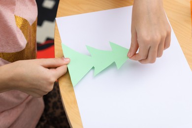 Photo of Girl making art project at table indoors, closeup