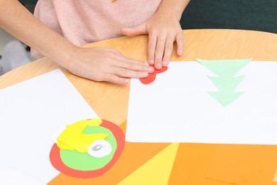 Photo of Girl making art project at table indoors, closeup