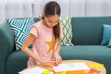 Photo of Girl making art project at table indoors