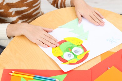 Photo of Girl making art project at table indoors, closeup