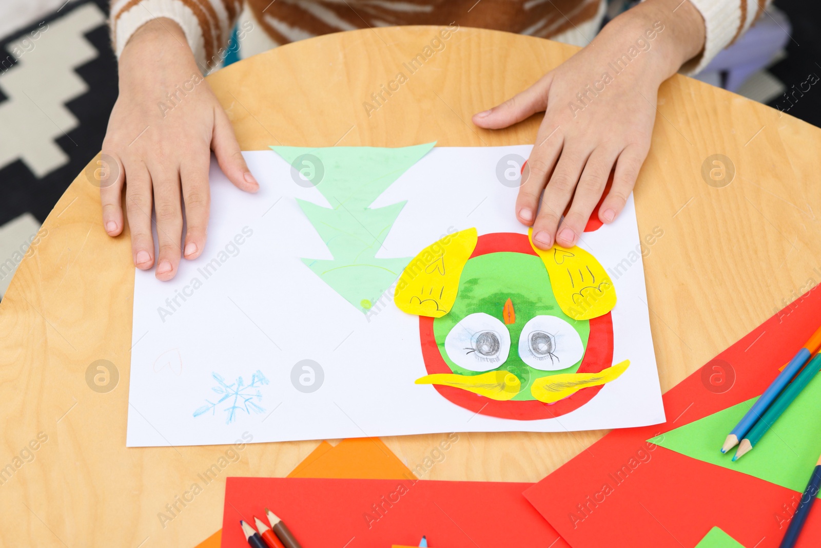 Photo of Girl making art project at table indoors, closeup