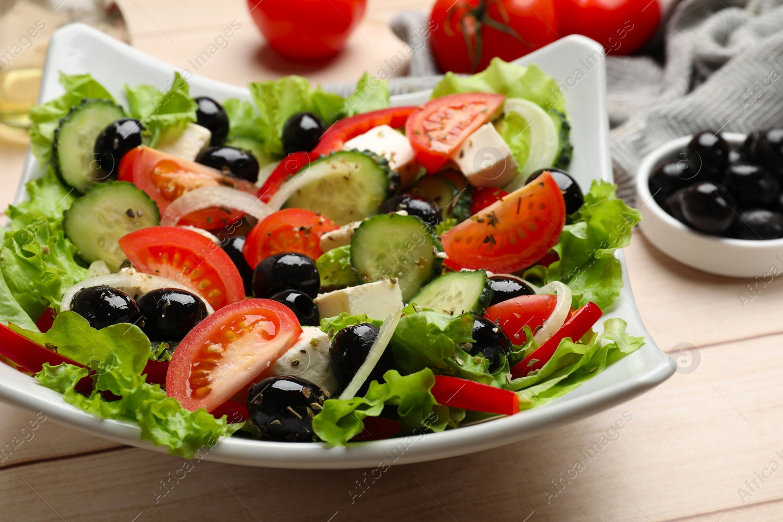 Delicious fresh Greek salad on white wooden table, closeup Photo of Delicious fresh Greek salad on white wooden table, closeup