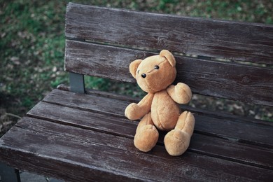 Photo of Lost brown teddy bear on wooden bench in park