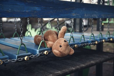 Photo of Lost brown teddy bear on playground outdoors