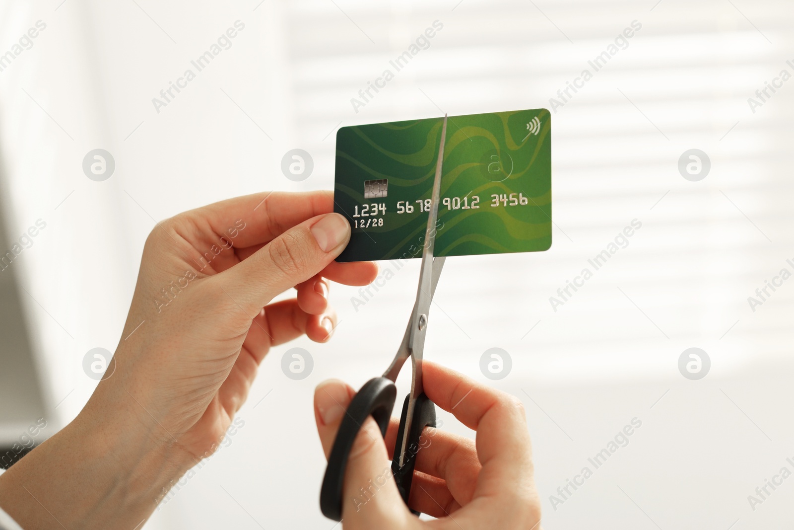 Photo of Woman cutting plastic credit card indoors, closeup