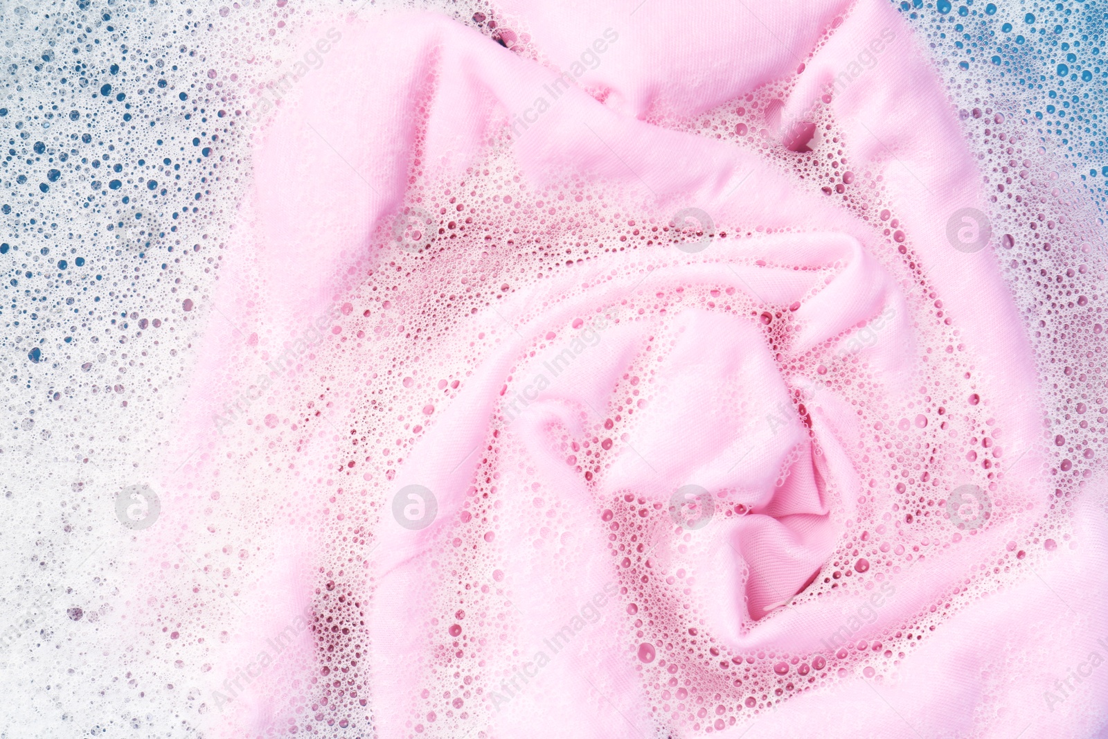 Photo of Pink clothes soaked in water before washing, top view