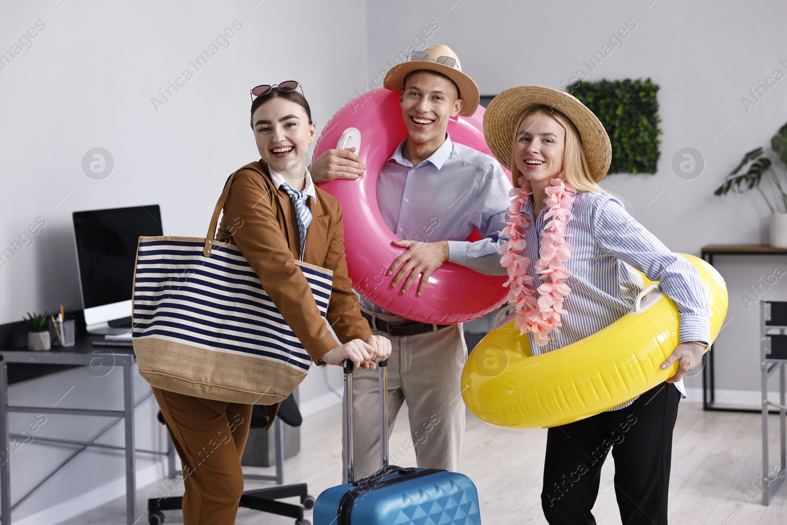 Photo of Colleagues with different beach accessories having fun in office