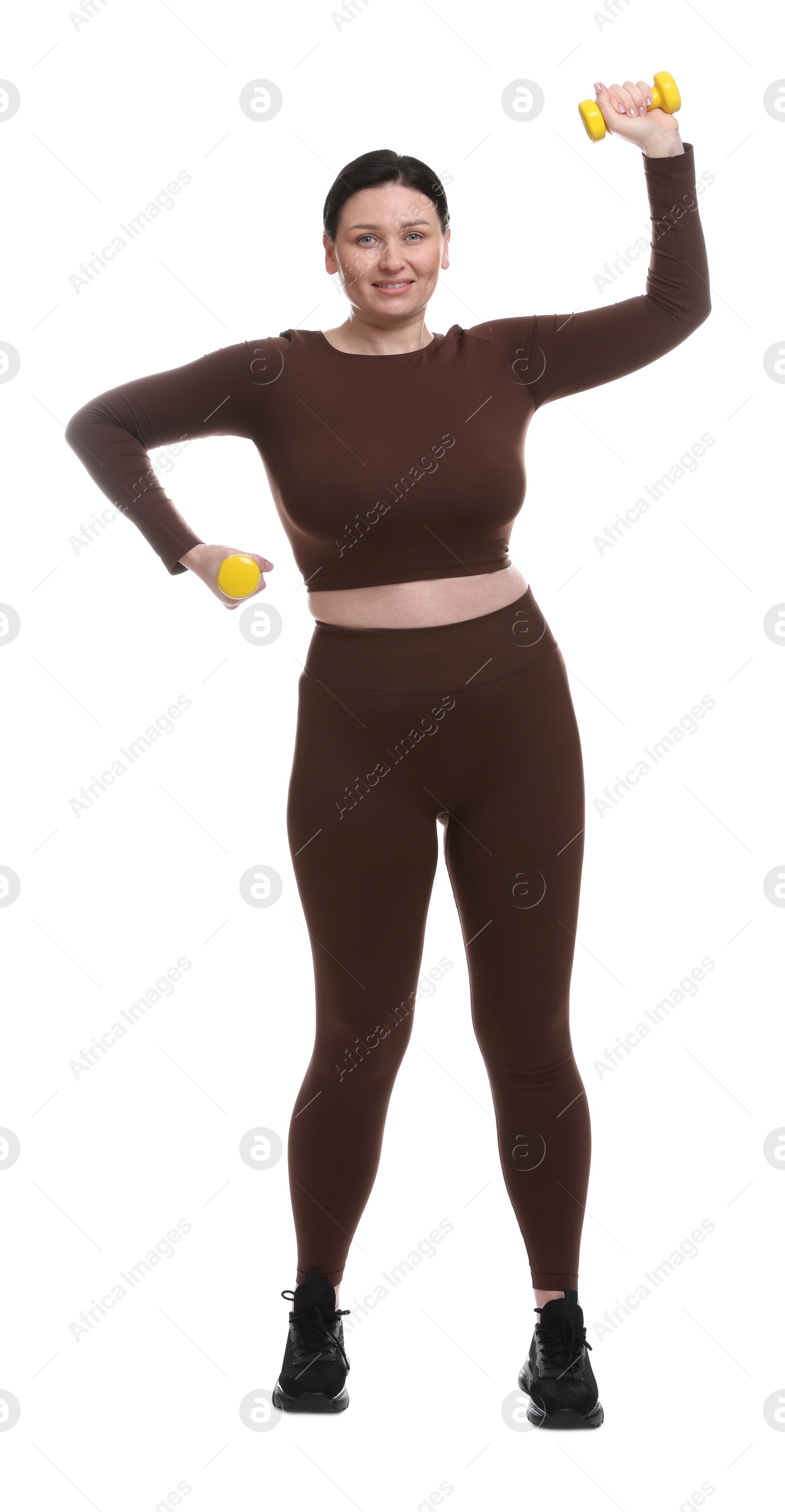 Photo of Plus size woman in gym clothes doing exercise with dumbbells on white background