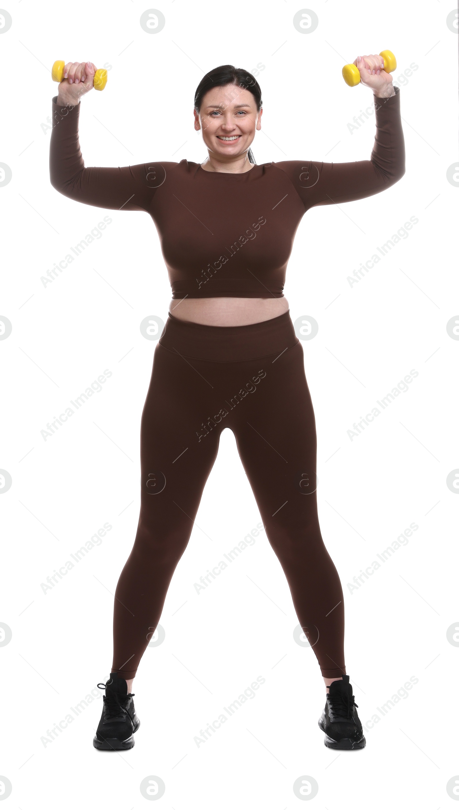 Photo of Plus size woman in gym clothes doing exercise with dumbbells on white background