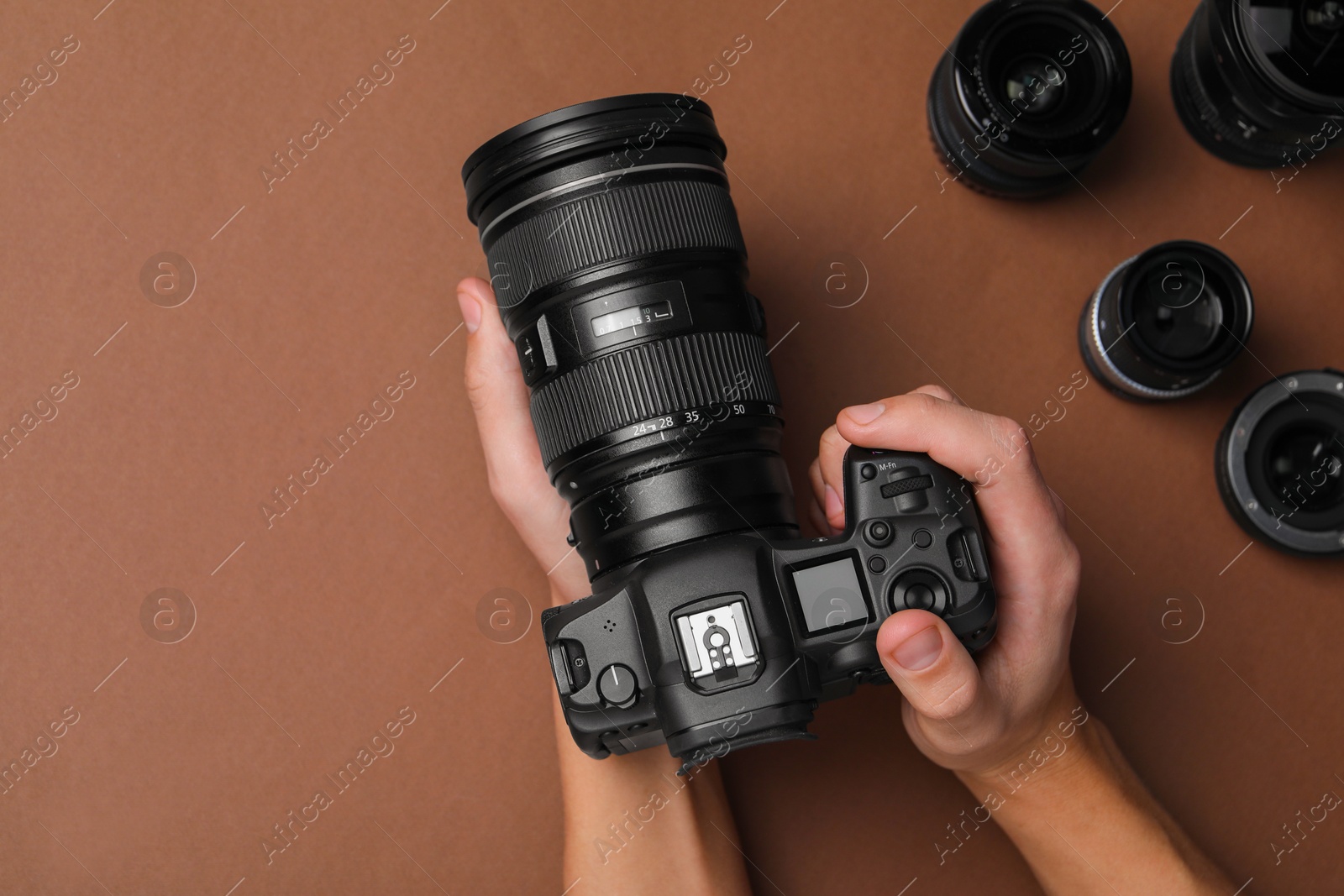 Photo of Photographer with professional camera on brown background, top view