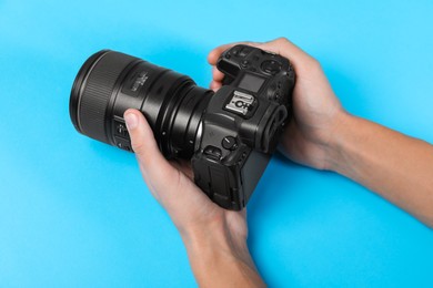 Photo of Photographer with professional camera on light blue background, above view