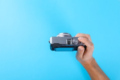 Photo of Photographer with vintage camera on light blue background, above view. Space for text