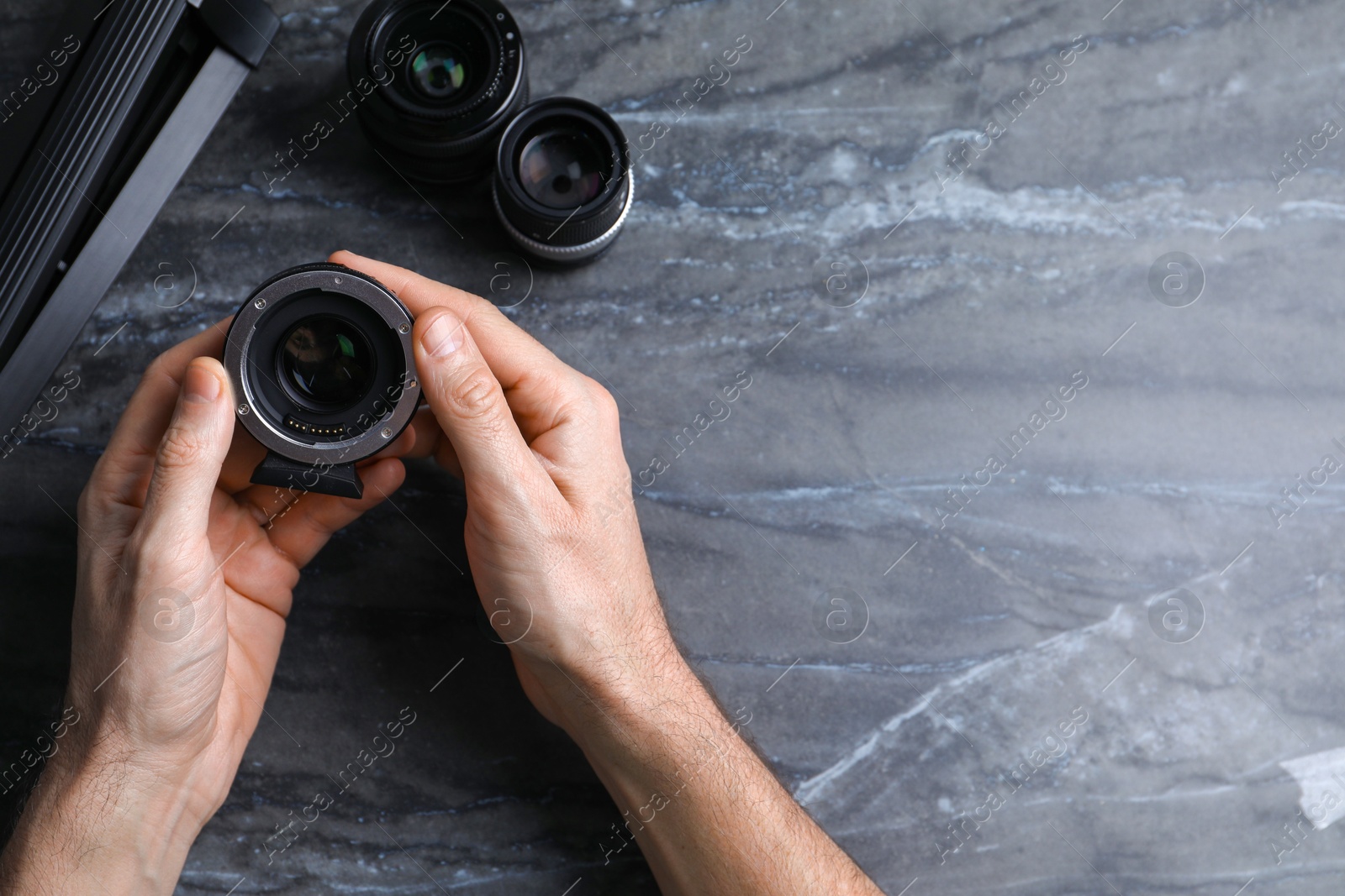 Photo of Photographer with camera lens at gray marble table, top view. Space for text