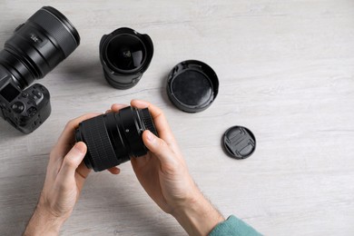 Photo of Photographer with camera lens at wooden table, above view. Space for text