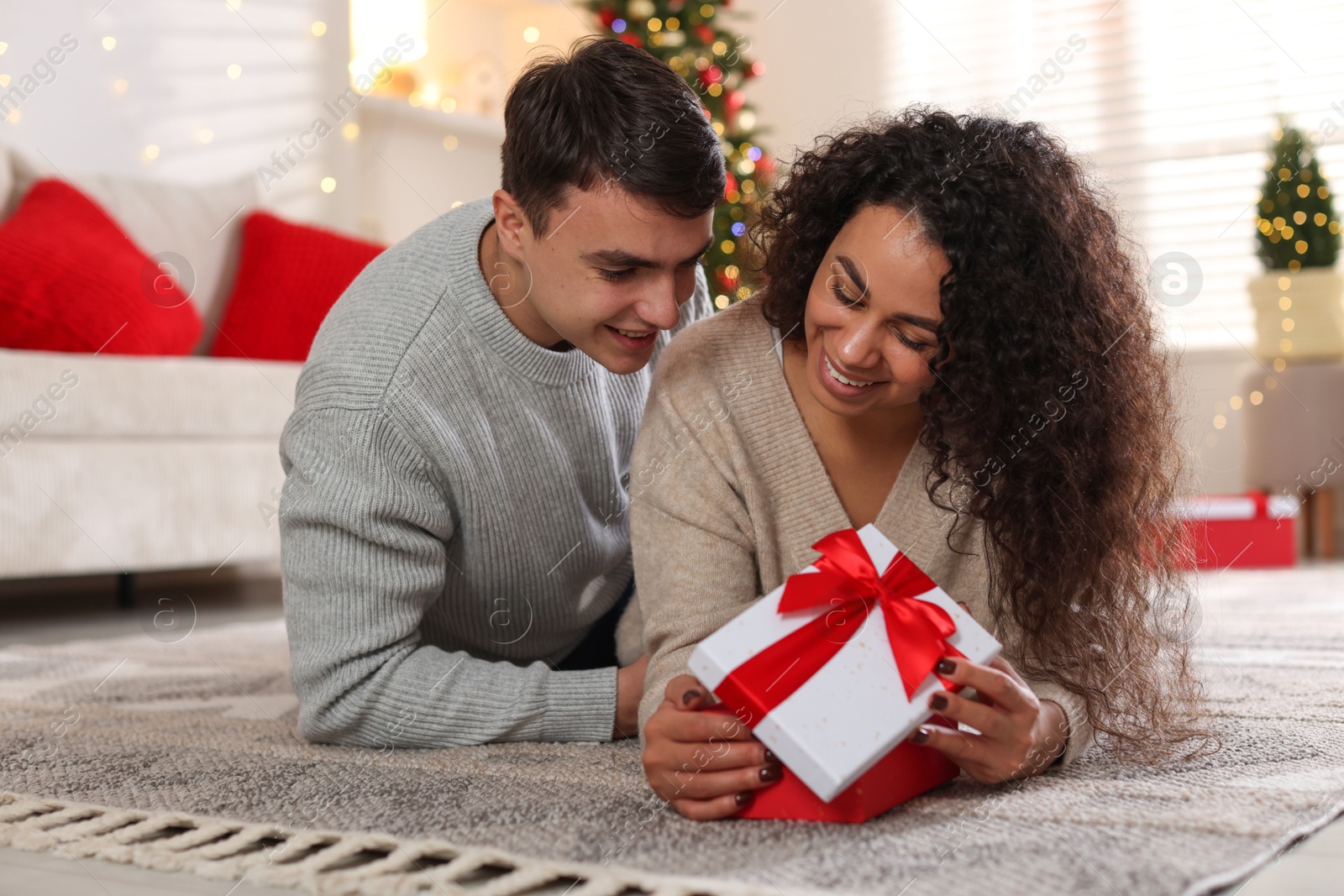 Photo of Happy couple with Christmas gift spending time together at home