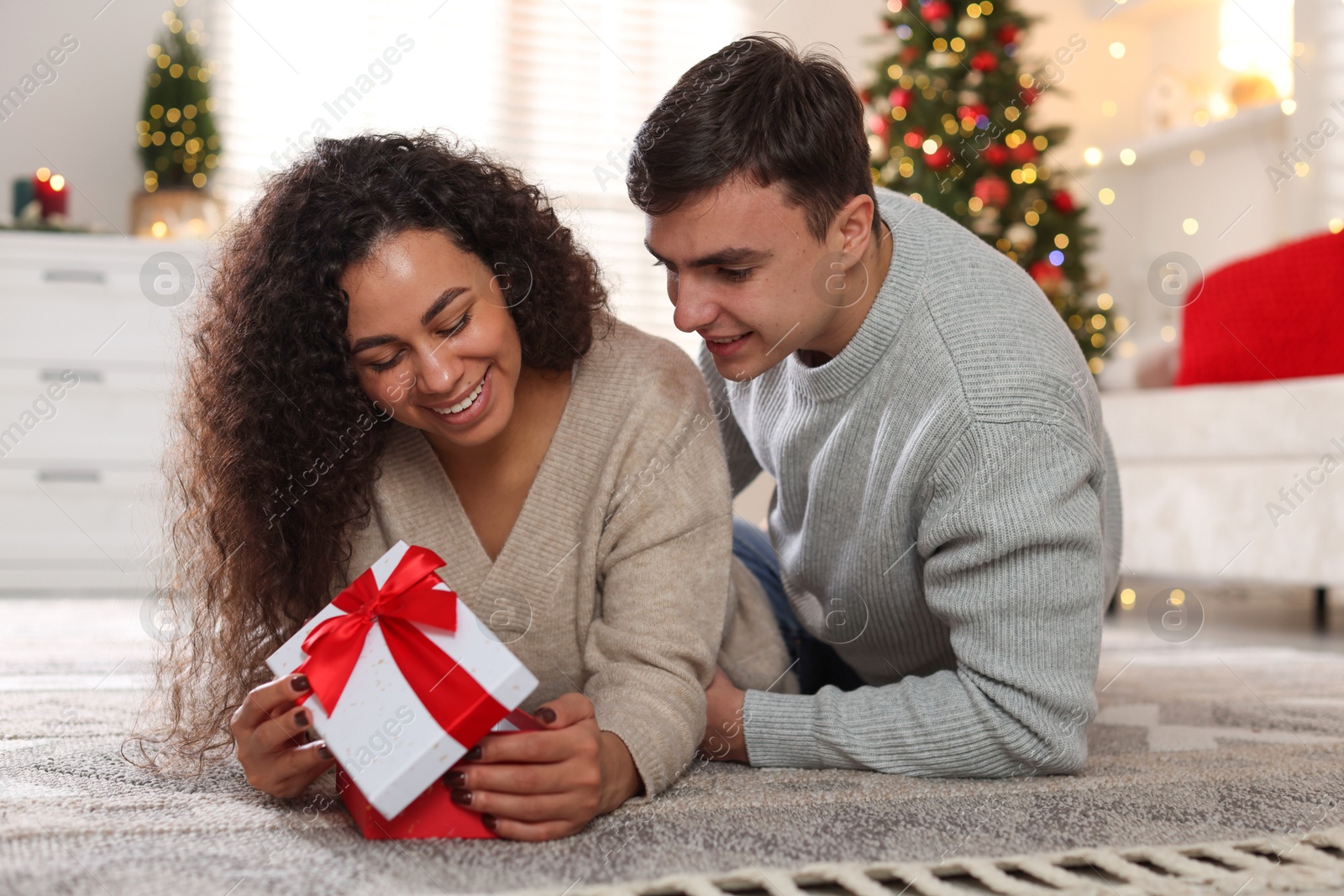 Photo of Happy couple with Christmas gift spending time together at home