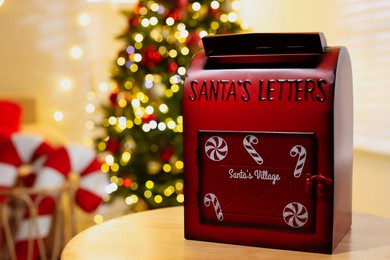 Photo of Santa Claus mailbox on wooden table indoors, space for text. Christmas atmosphere