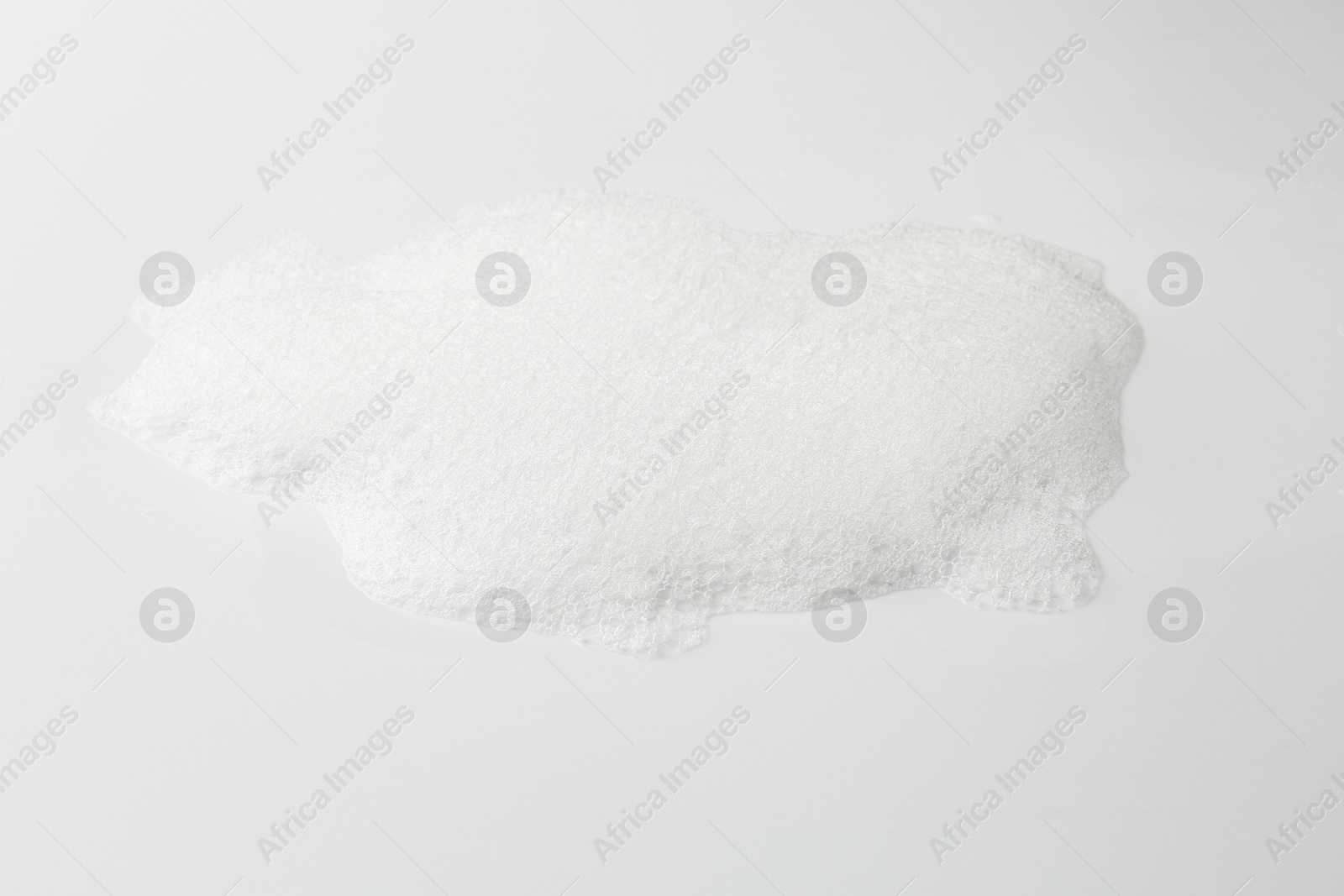 Photo of Detergent foam with bubbles on white background, closeup