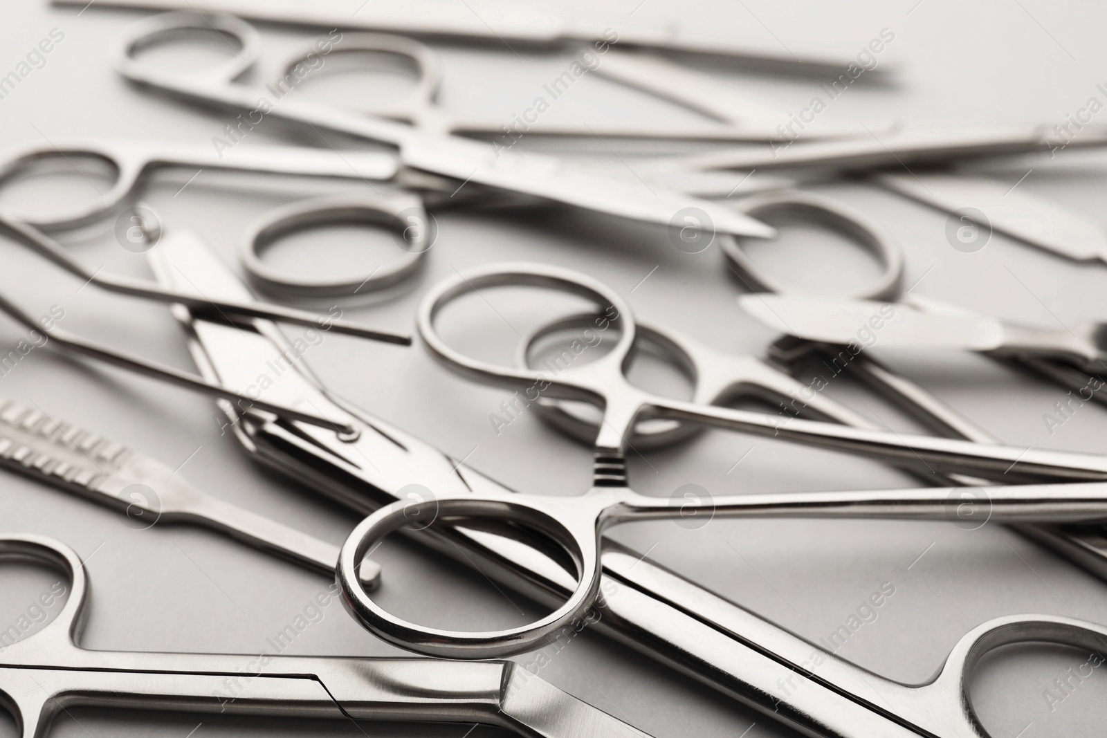 Photo of Different surgical instruments on grey background, closeup