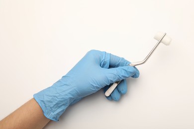 Photo of Doctor holding surgical tweezers with gauze on light background, top view