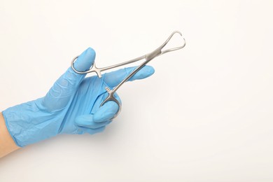 Photo of Doctor holding backhaus forceps on light background, top view with space for text. Surgical tool