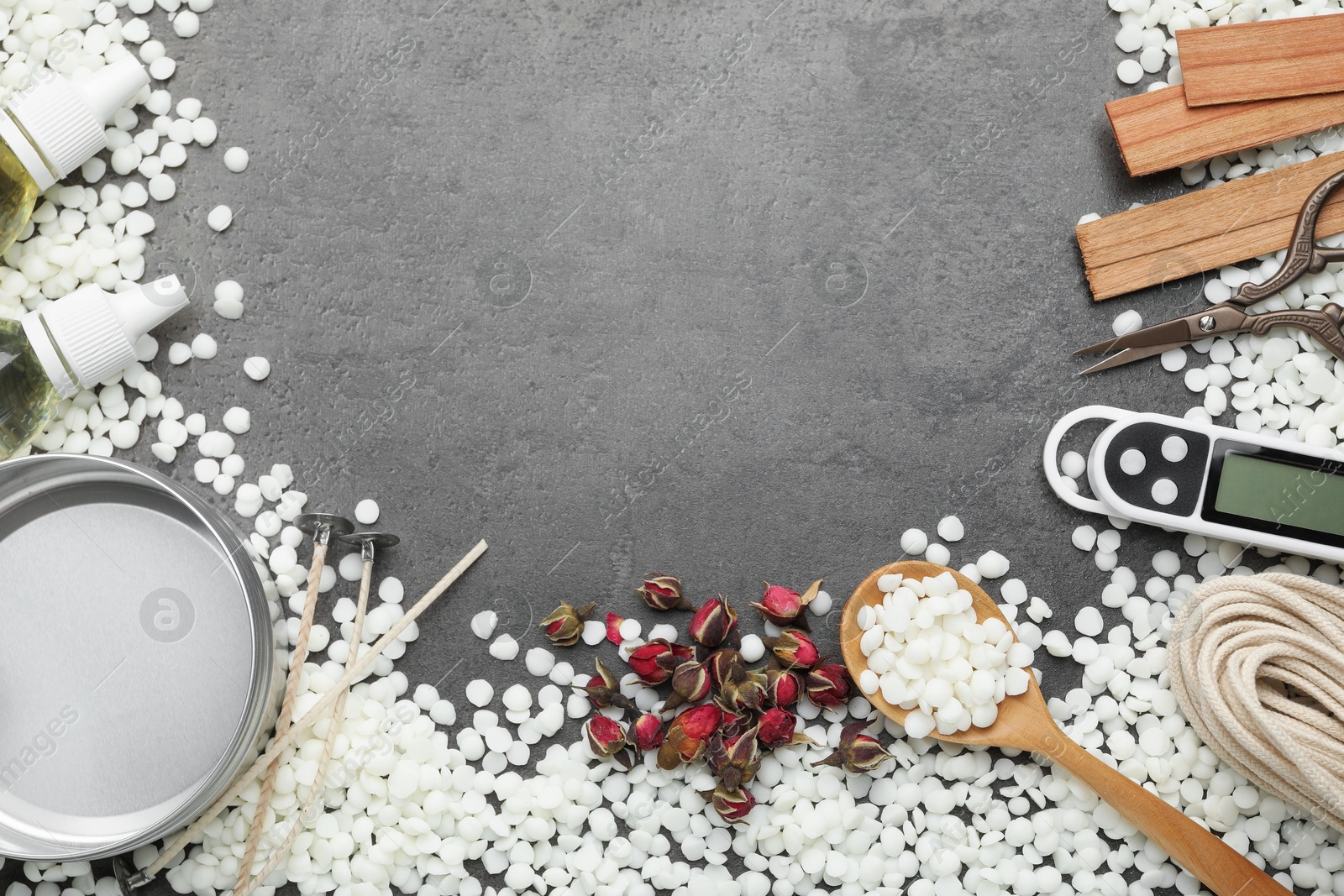 Photo of Soy wax and other supplies for making candles on grey table, flat lay. Space for text