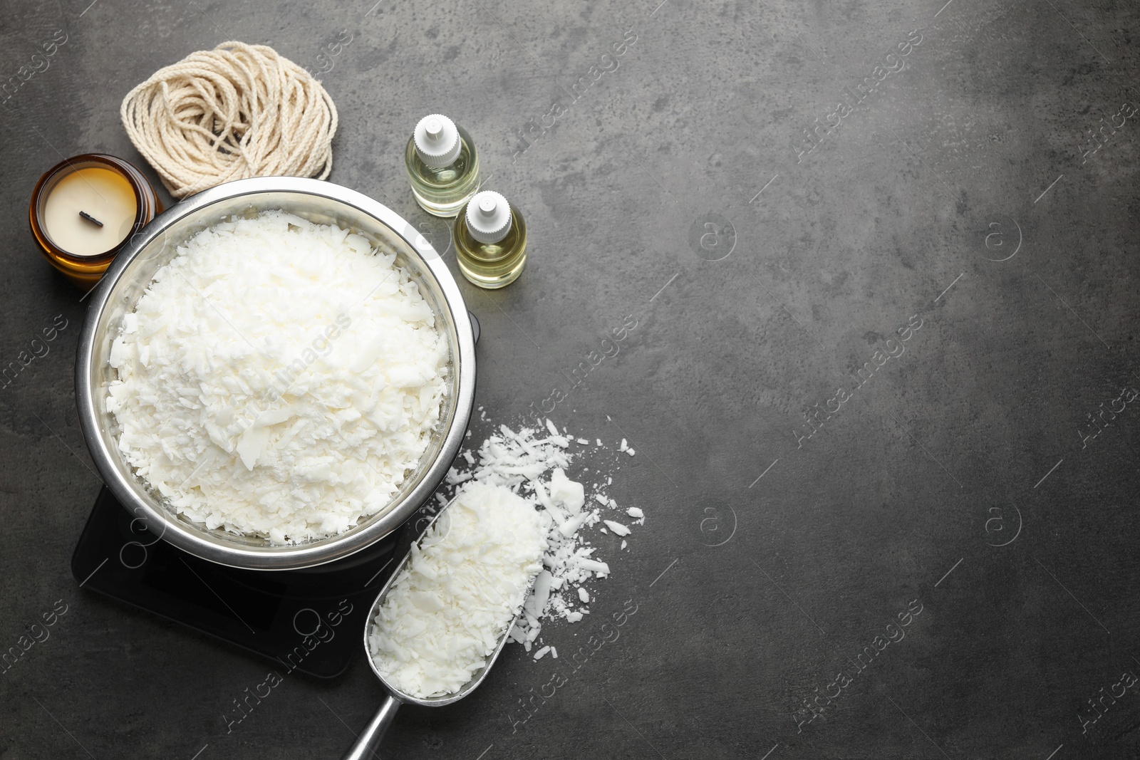 Photo of Soy wax and other supplies for making candles on grey table, flat lay. Space for text